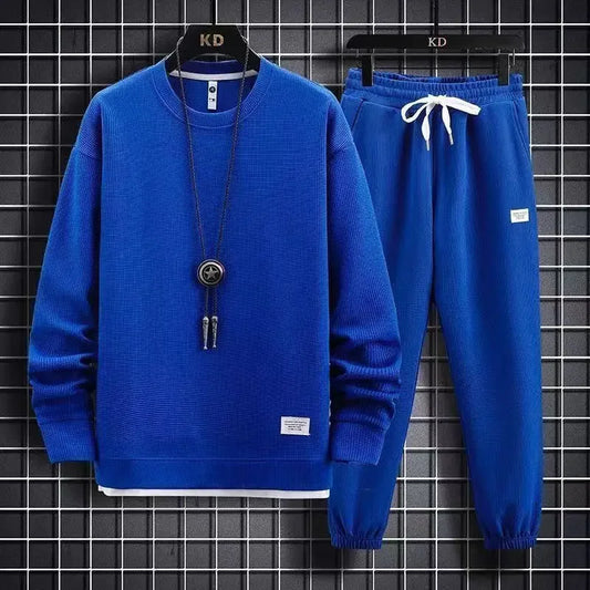 Blue sweater and pants set with a necklace on a checkered background