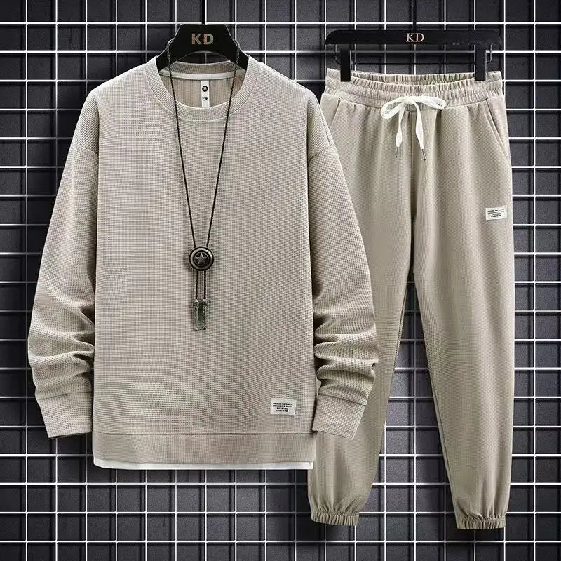 Beige tracksuit with a necklace on a black grid background