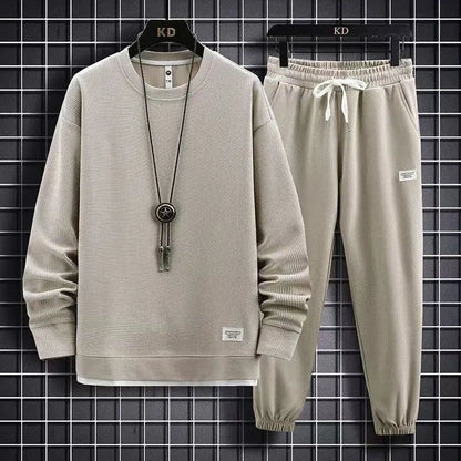 Beige tracksuit with a necklace on a black grid background